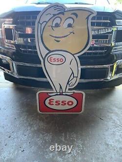 Panneau de style ancien vintage de la marque Esso avec la silhouette d'un petit garçon en goutte d'huile.